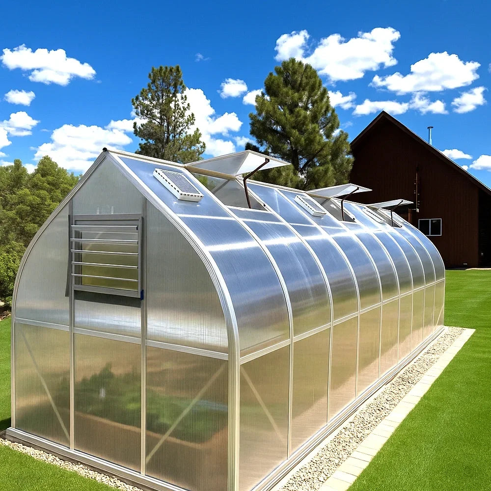 Metal aluminum greenhouse on a grassy area with trees and a clear blue sky in the background