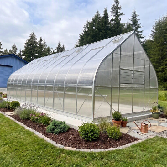 Polycarbonate greenhouse with garden bed in front, surrounded by trees and a blue building
